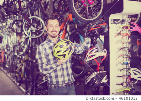 Man considering the range of helmets Man considering the range of helmets 46101012