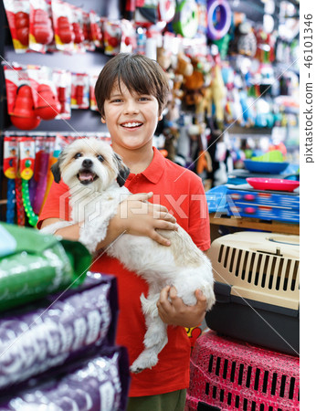 Portrait of happy teen boy with his little dog visiting pet supplies shop with mother 46101346