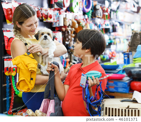 boy and his mother looking for supplies for little dog boy and his mother looking for supplies for little dog 46101371