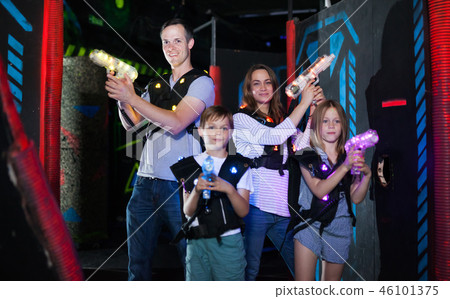 Parents and children playing laser tag Parents and children playing laser tag 46101375
