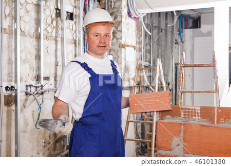 Bricklayer installing brick wall Bricklayer installing brick wall 46101380