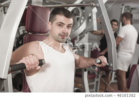 Man training on fitness machine in gym Man training on fitness machine in gym 46101382