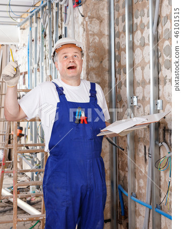 Happy contractor pointing pen up while planning building works, having good idea or smart construction solution Happy contractor pointing pen up while planning building works, having good idea or smart construction solution 46101515