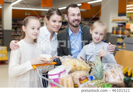 family is standing with trolley with food family is standing with trolley with food 46101521