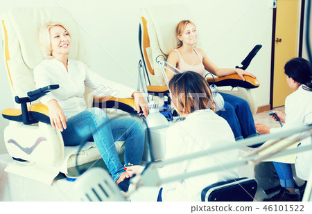 Two clients having pedicure 46101522