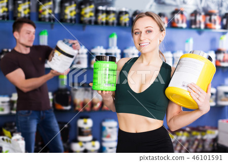 sporty woman holding big cans of sport nutrition sporty woman holding big cans of sport nutrition 46101591