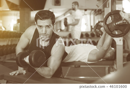 Guy during workout in gym with dumbbells Guy during workout in gym with dumbbells 46101600