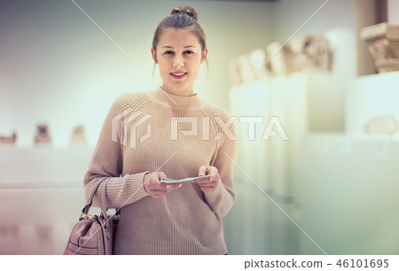 Girl looking with interest at ancient sculptures in museum, using guidebook Girl looking with interest at ancient sculptures in museum, using guidebook 46101695
