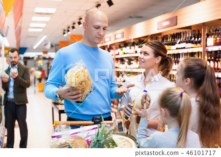 Family is looking on shelves with products in the supermarket. Family is looking on shelves with products in the supermarket. 46101717