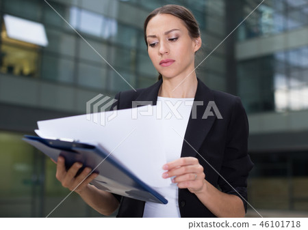 Serious businesswoman is dissatisfied of the results of the financial report Serious businesswoman is dissatisfied of the results of the financial report 46101718
