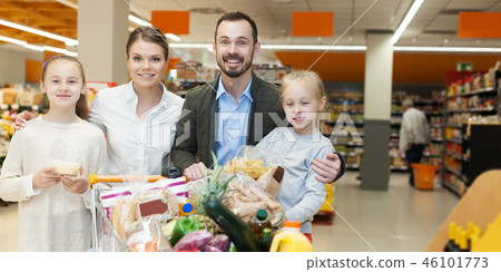 family is standing with trolley with food family is standing with trolley with food 46101773