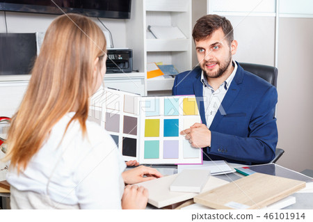 Competent seller in showroom helping young female client to choose furniture materials for her apartment Competent seller in showroom helping young female client to choose furniture materials for her apartment 46101914