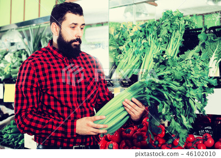 Shop assistant demonstrating celery Shop assistant demonstrating celery 46102010