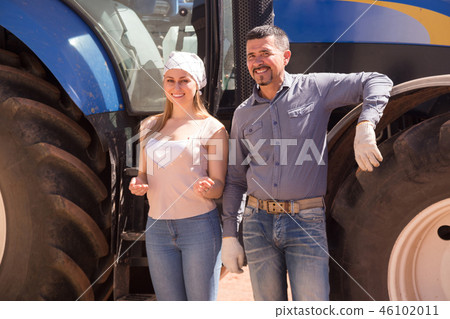 Two farmers close to huge tractor. 46102011