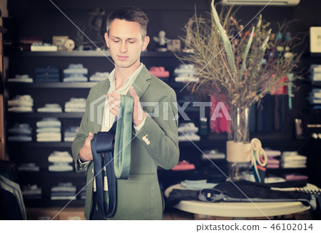 Cheerful man choosing new tie Cheerful man choosing new tie 46102014