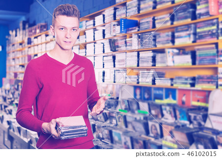 Guy holding CD in shop Guy holding CD in shop 46102015