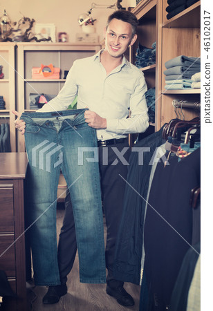Brunette guy deciding on new trousers Brunette guy deciding on new trousers 46102017