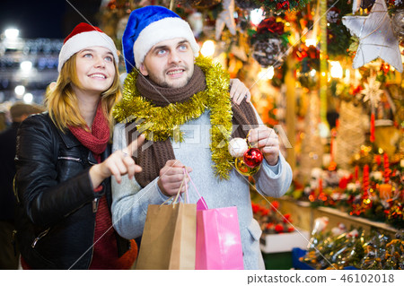 Couple in hat at Christmas Fair, girl points to decorations Couple in hat at Christmas Fair, girl points to decorations 46102018