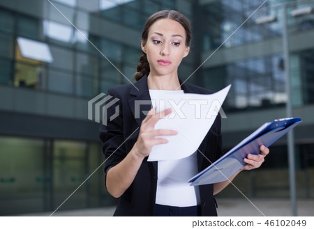Woman is examining documents Woman is examining documents 46102049