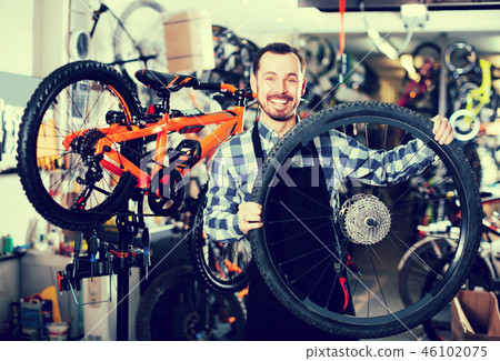 Man holding a bicycle wheel 46102075