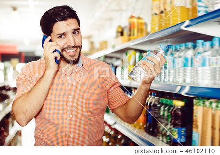 Glad male is talking on mobile in market Glad male is talking on mobile in market 46102110