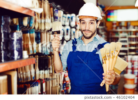 foreman in blue overalls choosing brushes foreman in blue overalls choosing brushes 46102404