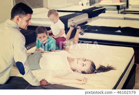 Girl with her family testing quality of mattress 46102579