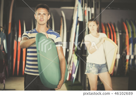 Young man with surfboard in nautical shop Young man with surfboard in nautical shop 46102689