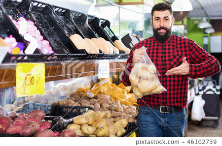 Young male seller offering potatoes 46102739