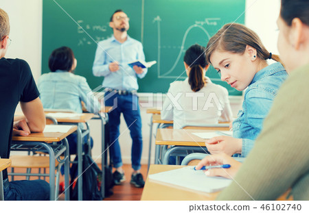 Two girl are sitting at the desk and talking in time lecture Two girl are sitting at the desk and talking in time lecture 46102740