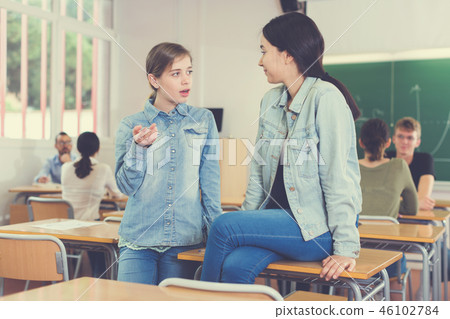 Two girl are sitting at the desk and talking about life Two girl are sitting at the desk and talking about life 46102784