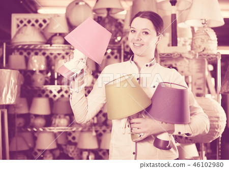 Pretty woman is looking on modern lamps Pretty woman is looking on modern lamps 46102980