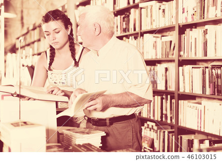 Old man with teenager are reading books 46103015