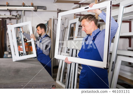 cheerful male professional labours with finished PVC profiles and windows cheerful male professional labours with finished PVC profiles and windows 46103131