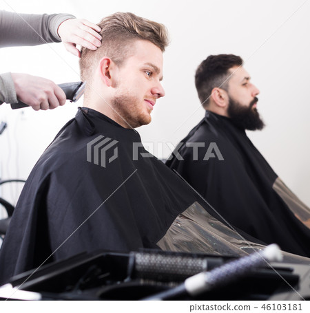 Young Men Having Their Hair Cut By Hairdressers Stock Photo