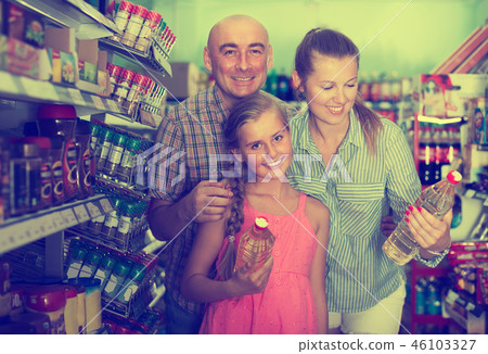 Mother with dad and daughter choosing sunflower oil Mother with dad and daughter choosing sunflower oil 46103327
