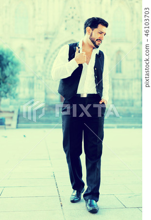 Man in formalwear walking along street Man in formalwear walking along street 46103703