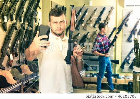 Guy taking selfie with rifle Guy taking selfie with rifle 46103705