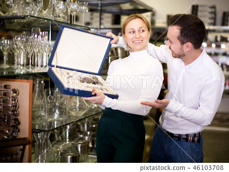Couple examining cutlery sets in dinnerware store Couple examining cutlery sets in dinnerware store 46103708