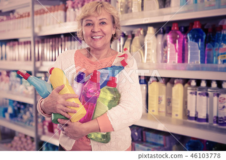 Female holding goods for cleaning home in chemical store 46103778