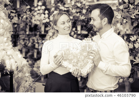 Young couple deciding on flower decoration Young couple deciding on flower decoration 46103790