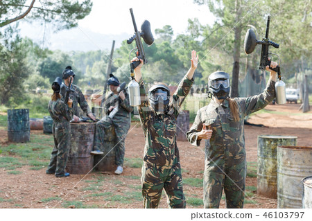 Cheerful young women in camouflage holding guns ready for playing paintball Cheerful young women in camouflage holding guns ready for playing paintball 46103797