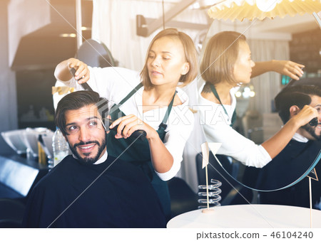female professional shaving male's hair 46104240