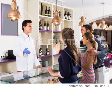 Hospitable pastryman serving positive visitors Hospitable pastryman serving positive visitors 46104505