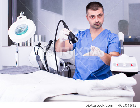 Beautician explaining action of cosmetological equipment Beautician explaining action of cosmetological equipment 46104682