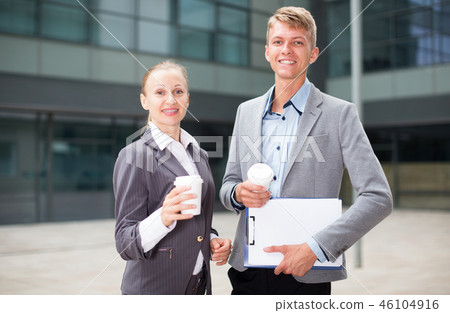 Portrait of couple who are standing with folder and coffee Portrait of couple who are standing with folder and coffee 46104916