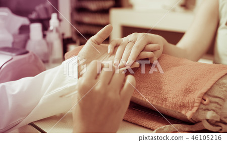 Closeup of hands receiving manicure 46105216