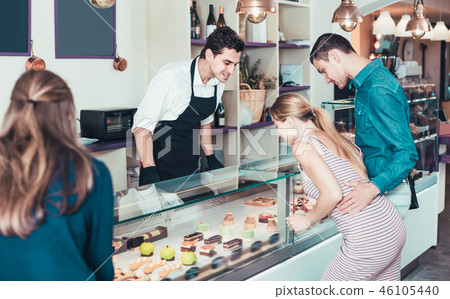 Ordinary seller helping friends to choose sweets 46105440
