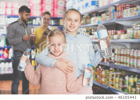 Two small sisters holding bottled water 46105441
