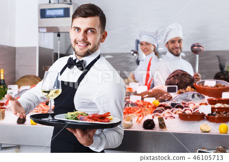 Waiter standing in fish restaurant Waiter standing in fish restaurant 46105713